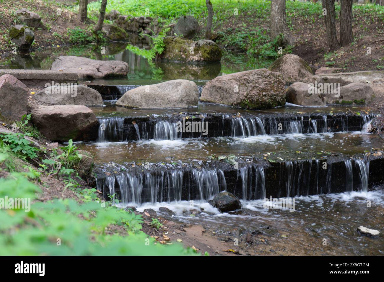 small artificial waterfall in the park. Stock Photo