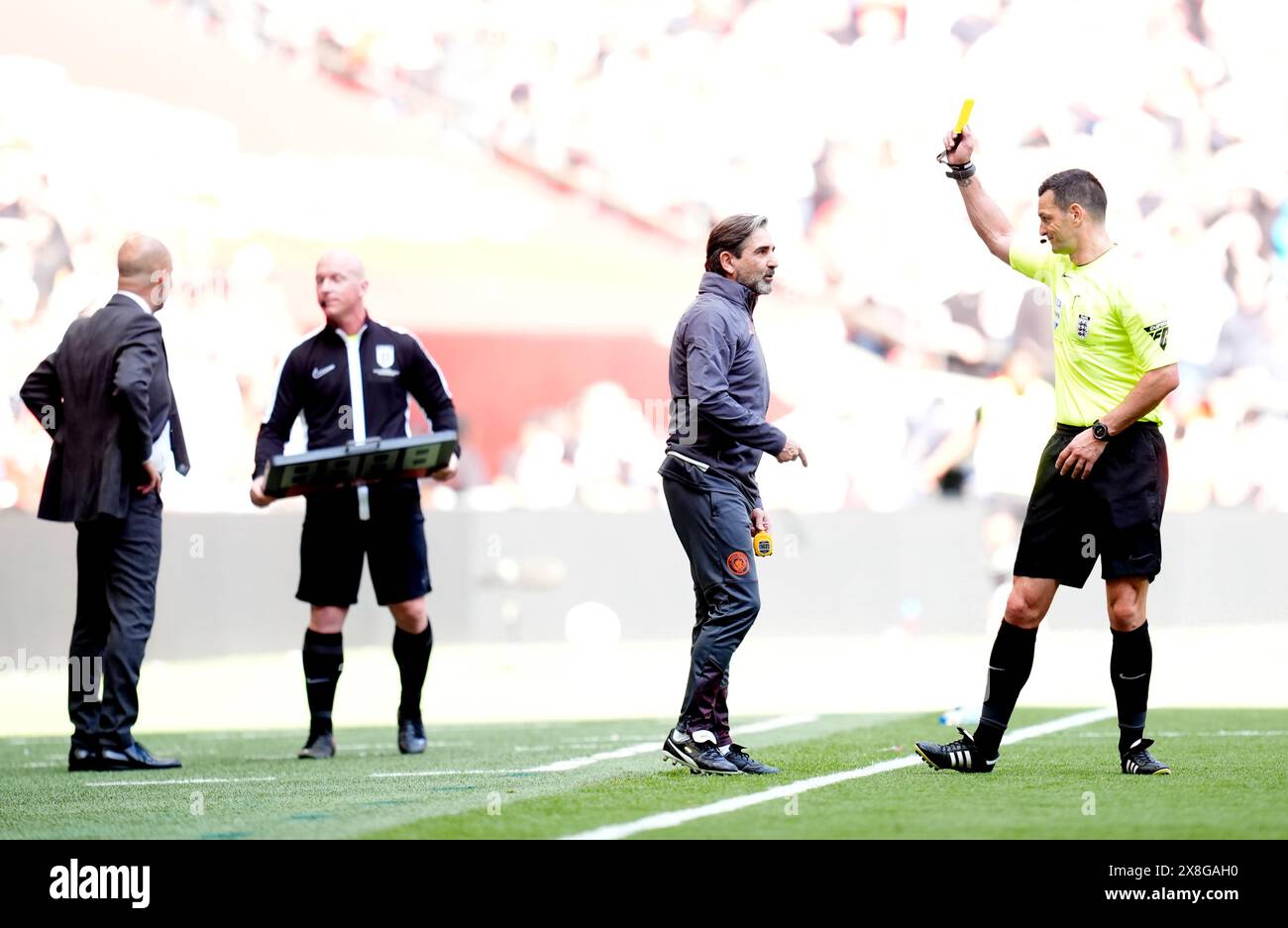 Manchester City Fitness Coach Lorenzo Buenaventura is shown a yellow card by Referee Andrew Madley during the Emirates FA Cup final at Wembley Stadium, London. Picture date: Saturday May 25, 2024. Stock Photo