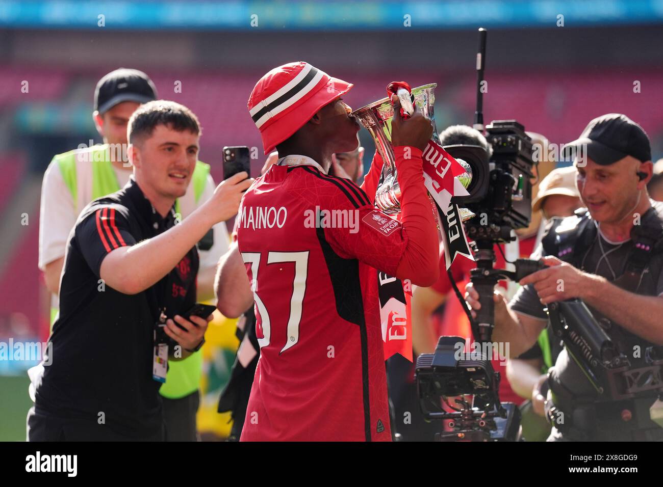 Manchester united's kobbie mainoo celebrates with the fa cup trophy