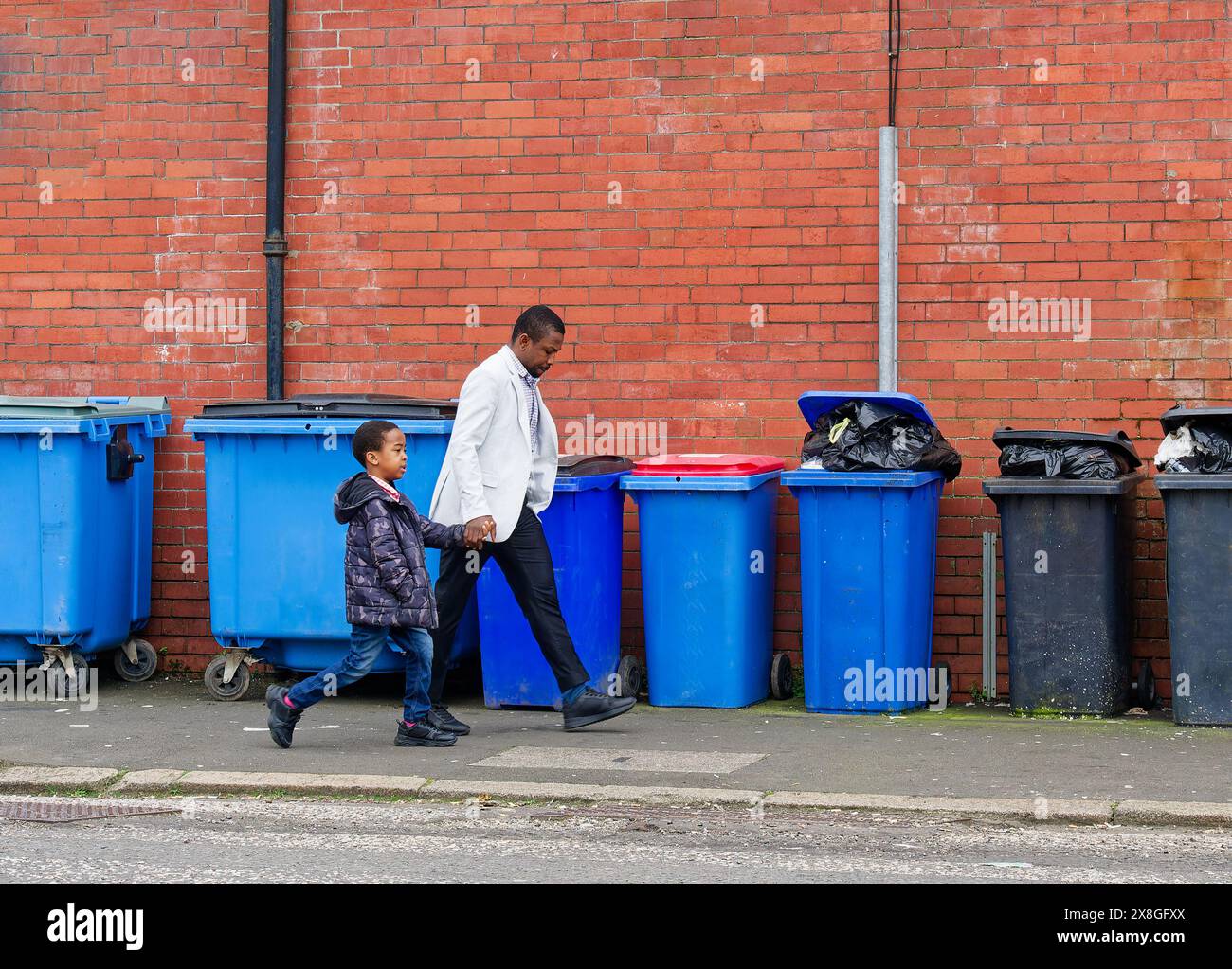 Wheelie bins on city street awaiting collection to be emptied Stock