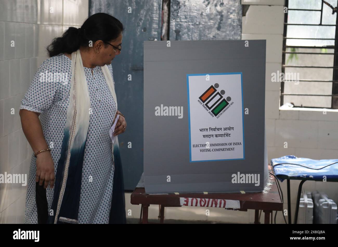 New Delhi, India. 25th May, 2024. A woman looks at the Electronic Voting Machines (EVM) after casting her vote at a polling station during the sixth phase of Lok Sabha General elections. Credit: SOPA Images Limited/Alamy Live News Stock Photo