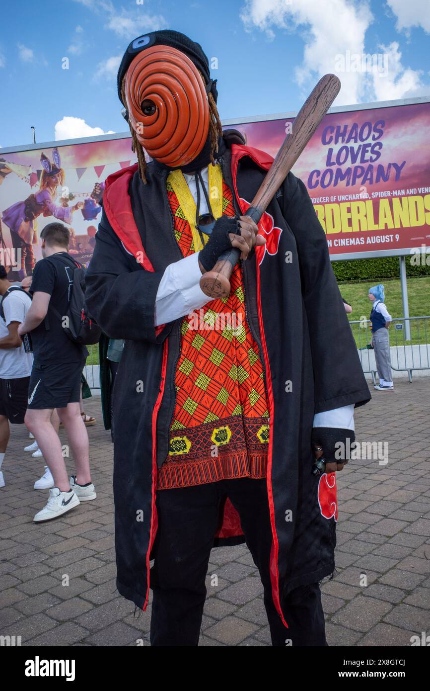 London, UK, 25th May, 2024. A visitor to day two of Comic Con London poses outside the venue wearing a mask and holding a baseball bat. Credit: James Willoughby/Alamy Live News Stock Photo
