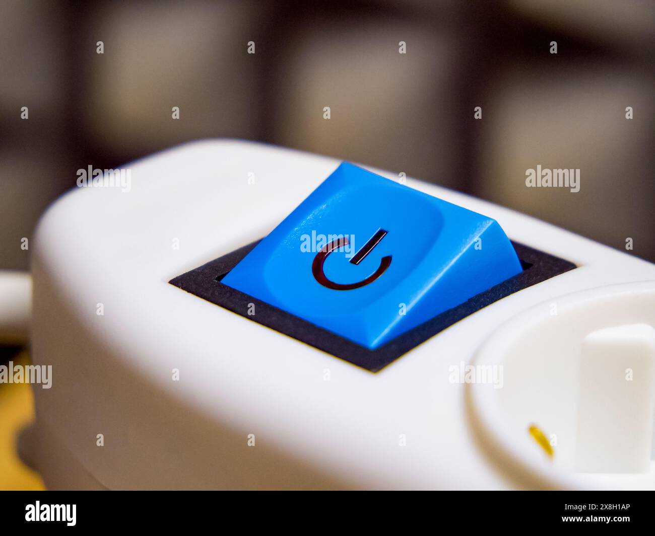 Blue power button with a symbol on white machinery, representing action and response. Stock Photo
