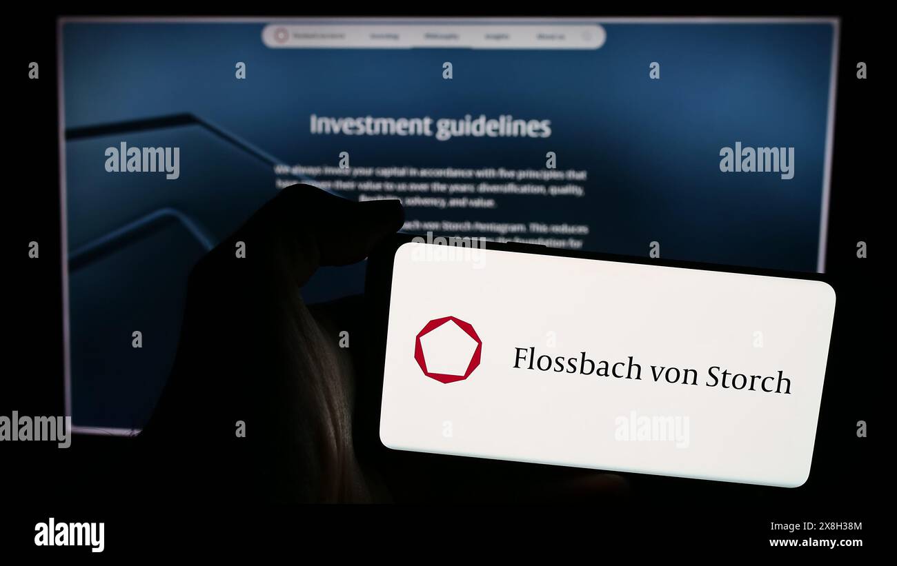 Person holding mobile phone with logo of German wealth management ...