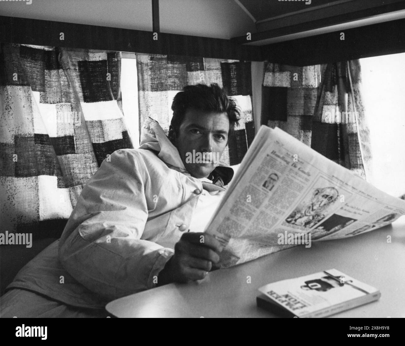 Candid Photo of CLINT EASTWOOD relaxing in a location trailer on the set of WHERE EAGLES DARE 1968 Director BRIAN G. HUTTON Story and Screenplay ALISTAIR MacLEAN Music RON GOODWIN  Gershwin-Kastner Productions / Winkast Film Productions / Metro Goldwyn Mayer Stock Photo