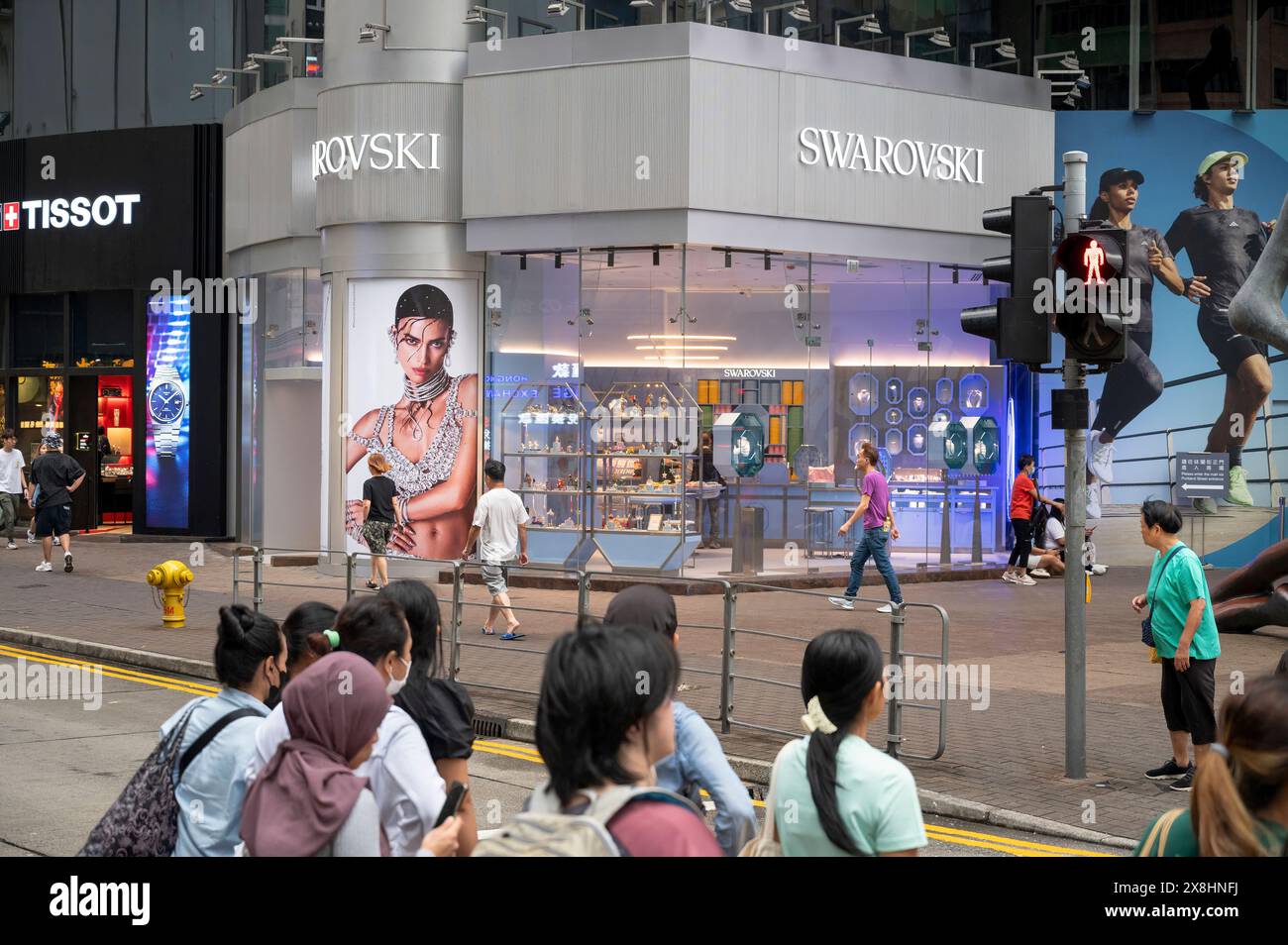 Pedestrians are seen outside the Austrian jewelry producer and luxury brand Swarovski and Swiss luxury watchmaker Tissot stores in Hong Kong Stock Photo