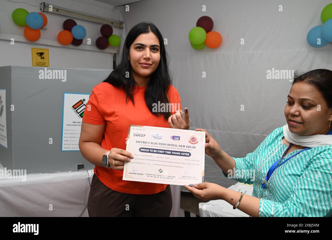 NEW DELHI, INDIA - MAY 25: First time voter Sanjana taking certificate after casting her vote during General Lok Sabha election at Nirman Bhawan on May 25, 2024 in New Delhi, India. Polling for the sixth phase of general elections concluded in 58 constituencies across six states and two Union territories, including all seven seats in Delhi. Voter turnout across six states and two Union Territories during Phase 6 polling has been recorded at approximately 58.84 per cent, according to the Voter Turnout App of the Election Commission. (Photo by Arvind Yadav/Hindustan Times/Sipa USA ) Stock Photo