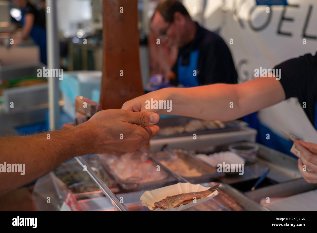 Paying for food at a market, handing over money Stock Photo