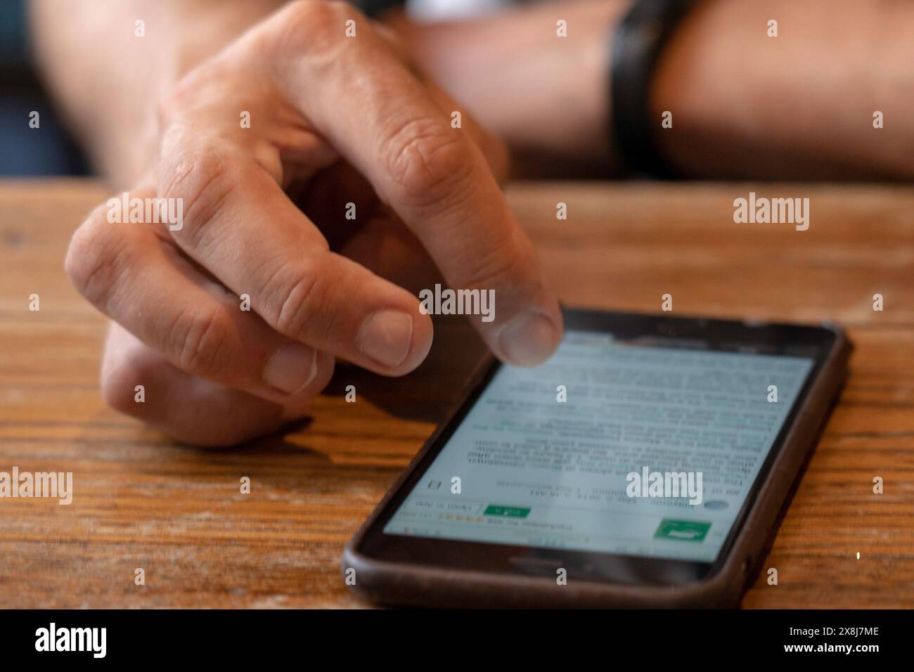 View of persons hand scrolling through there phone Stock Photo