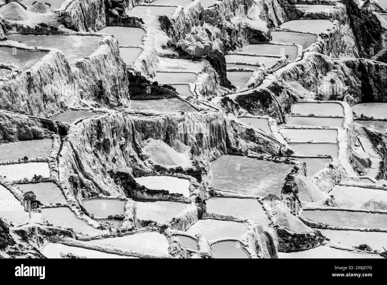 detail of the mountain salt pans with the white of the salt and the brown of the water which is turning into salt with evaporation in Peru in South Am Stock Photo