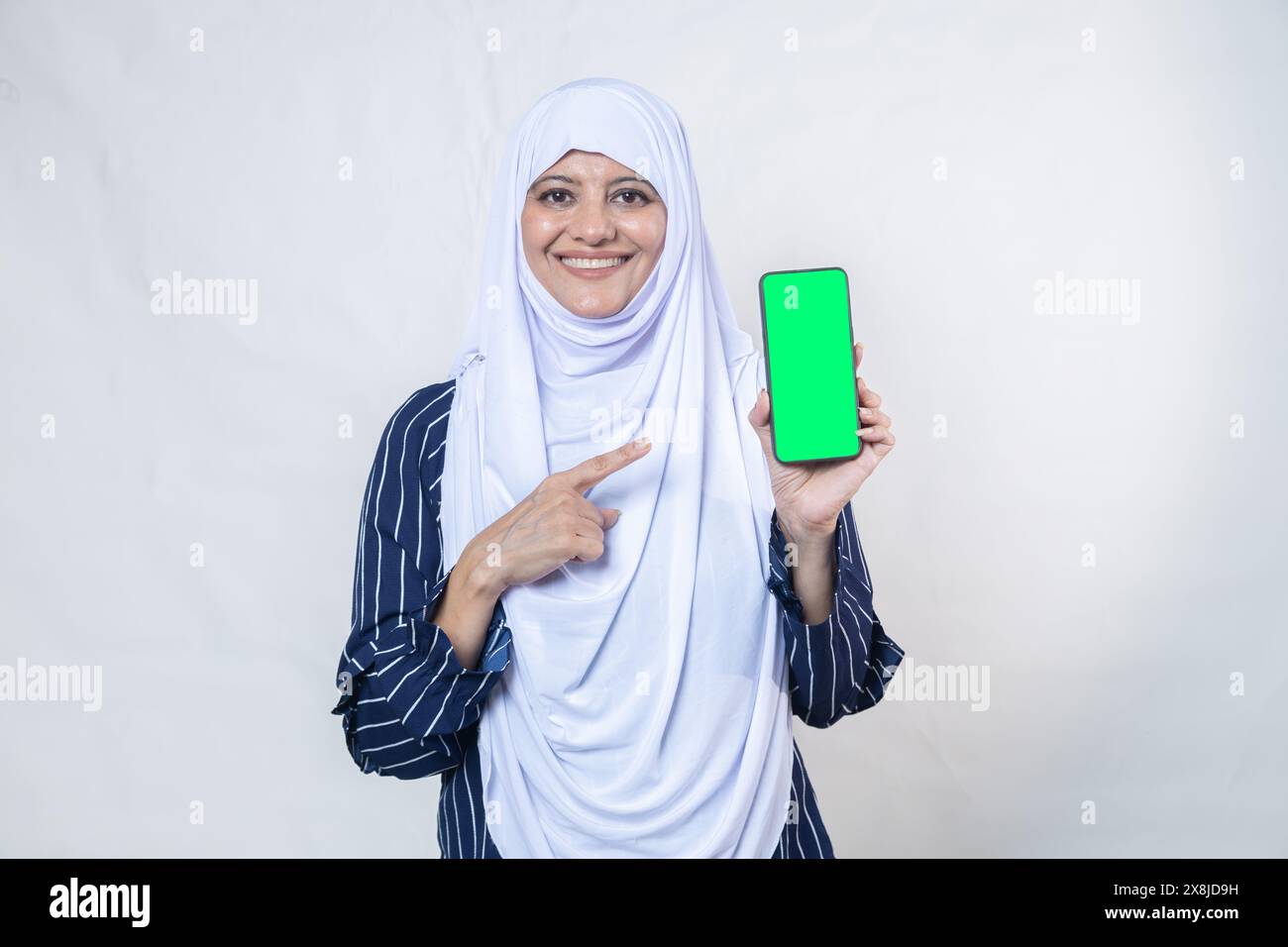 Portrait of happy indian muslim woman wearing hijab showing smart phone ...