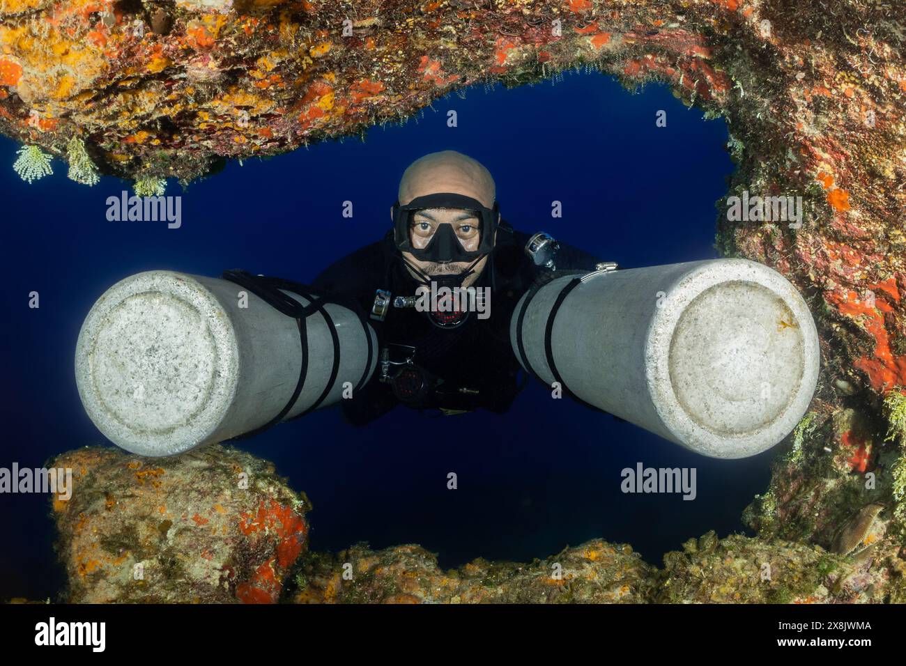 A classic shot of an advanced sidemount diver with his tanks unclipped