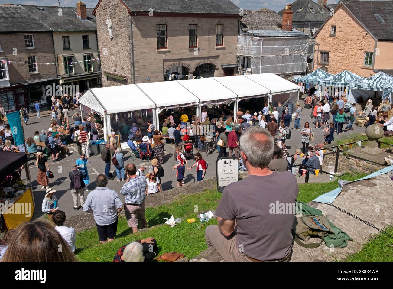 People visitors sitting relaxing by castle in HayonWye book town