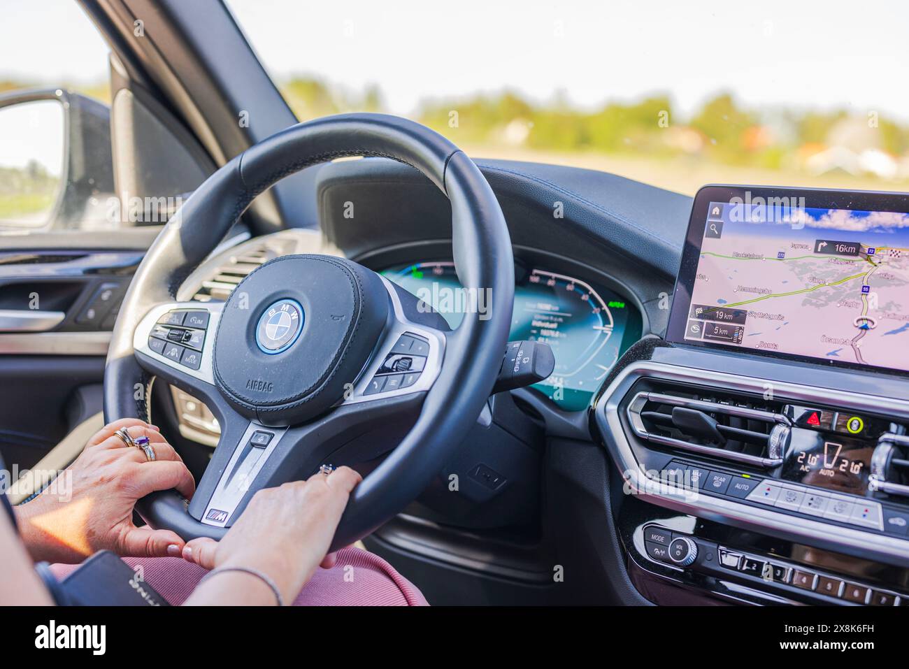 Close-up view of female hands on the steering wheel of the BMW iX3 ...