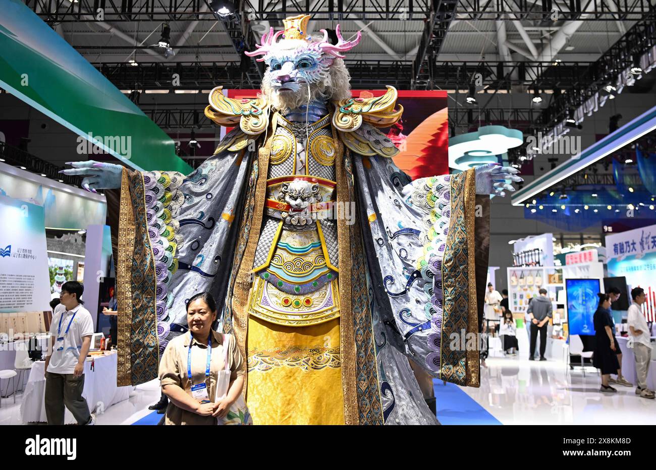 (240526) -- SHENZHEN, May 26, 2024 (Xinhua) -- A visitor poses for photos with a mechanical installation mimicking the dragon king, a lord over the sea in Chinese mythology, during the 20th China (Shenzhen) International Cultural Industries Fair (ICIF) in Shenzhen, south China's Guangdong Province, May 23, 2024. The 20th ICIF opened on Thursday in the southern Chinese metropolis of Shenzhen. The fair will showcase new business forms and new applications through the combination of multimedia such as AI and AR. (Xinhua/Deng Hua) Stock Photo