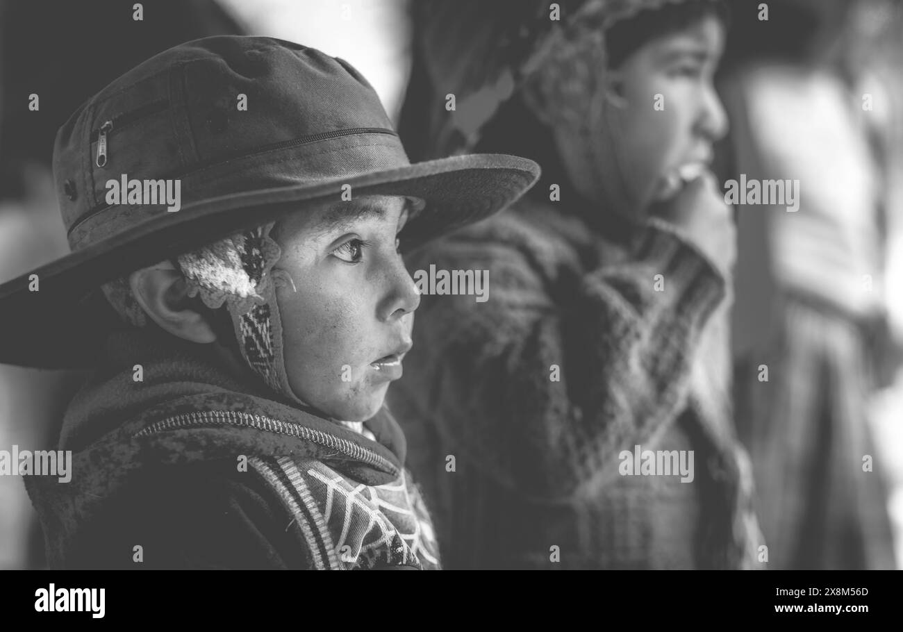 Peru, Cusco - 13 October 2018: Little boy in big brown titfer attentively looking, in Cusco. Black and white photo. Stock Photo