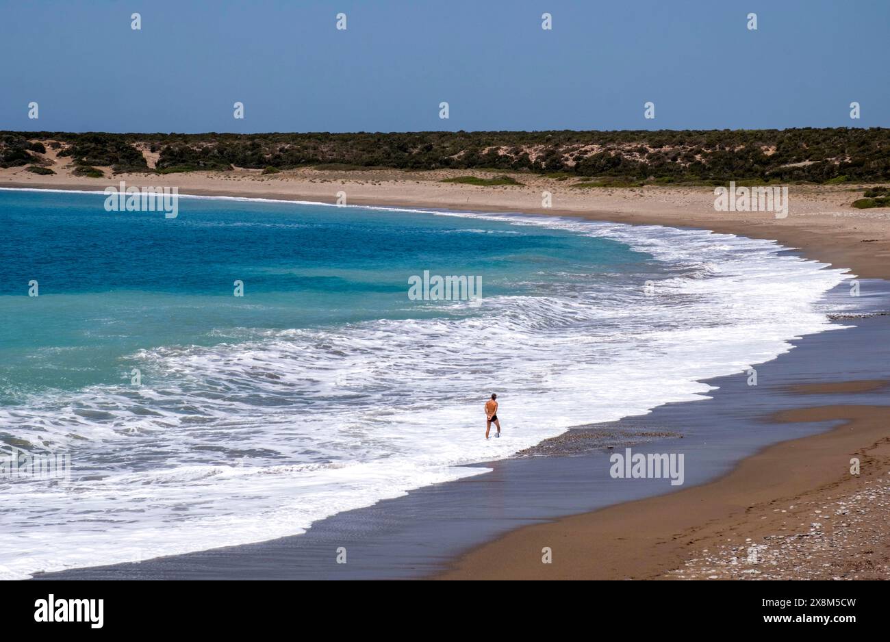 Man alone on a quiet sandy bay, Akamas place to yourselfPeninsula, Paphos district, Republic of Cyprus. Stock Photo