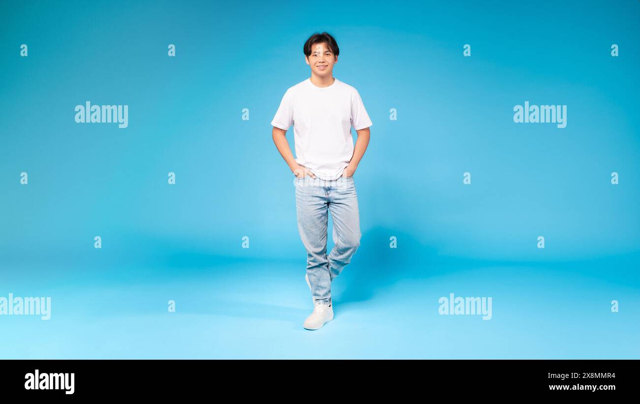 Guy Standing in Front of Blue Background Stock Photo