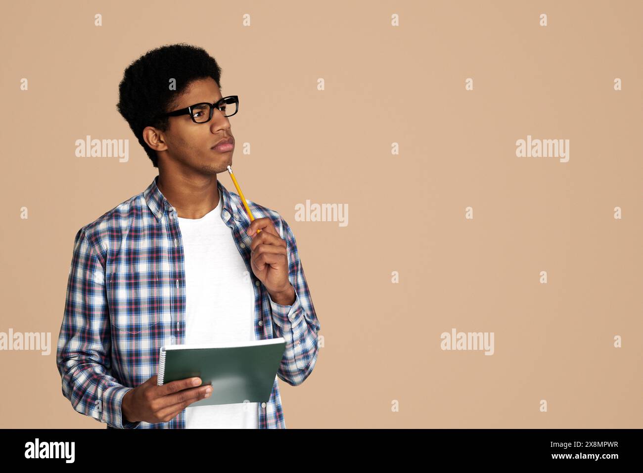 African-American Thoughtful Nerd Thinking about Test in Studio Stock Photo