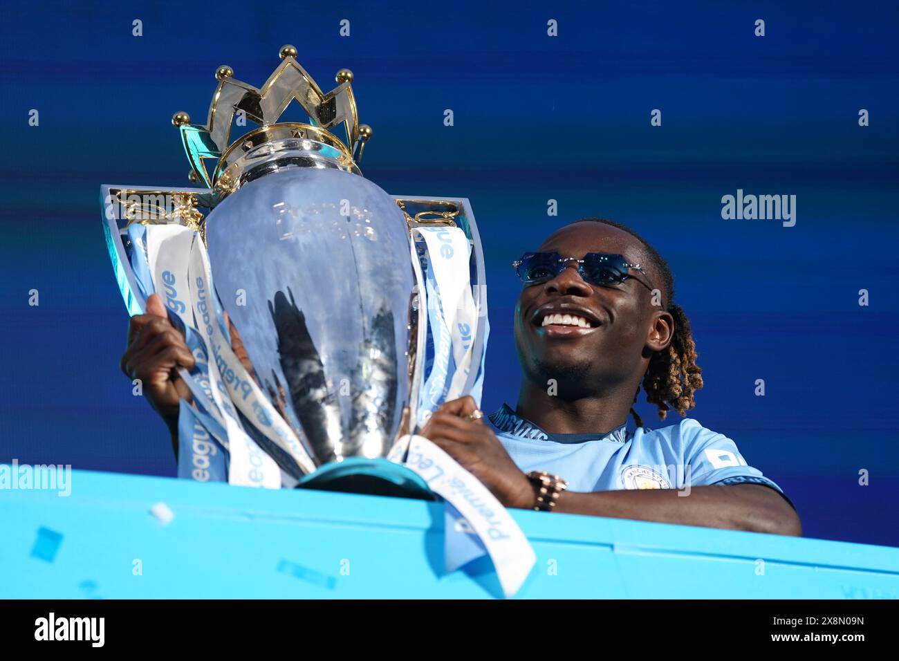 Jeremy Doku lifts the Premier League trophy during a trophy parade in ...