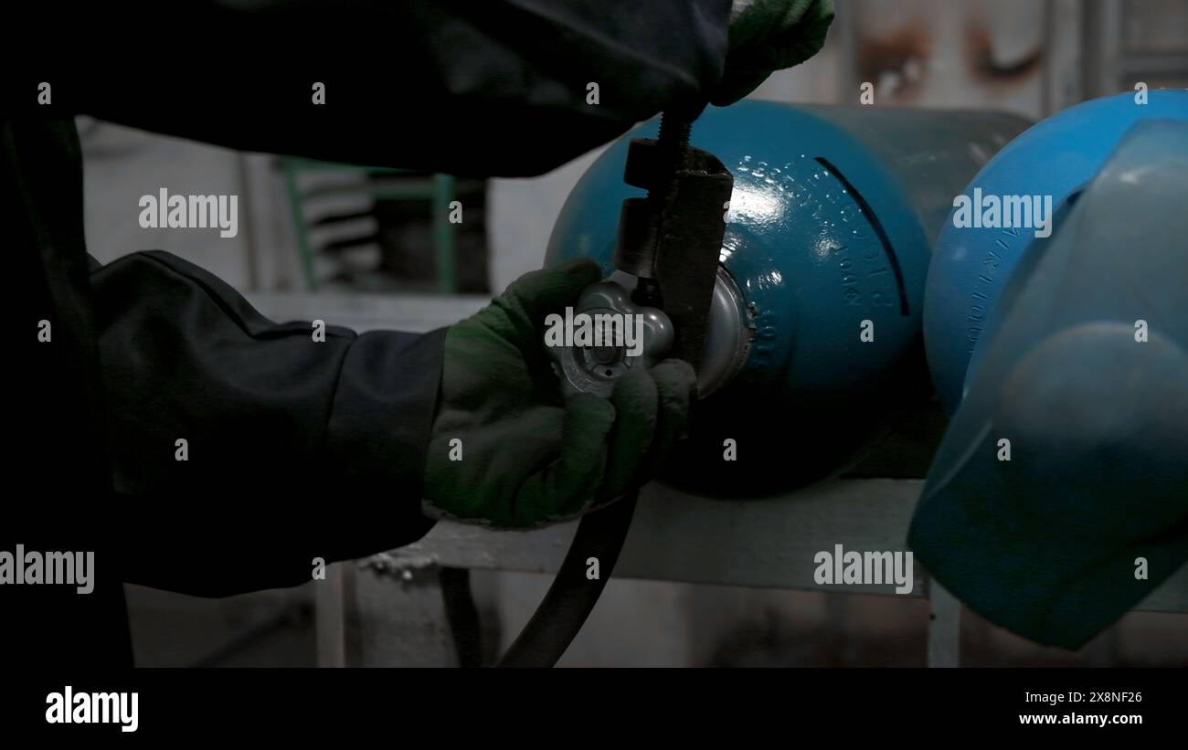 Golves Turning Machine Close up of worker in gloves turning gas cylinder valve. Clip ...