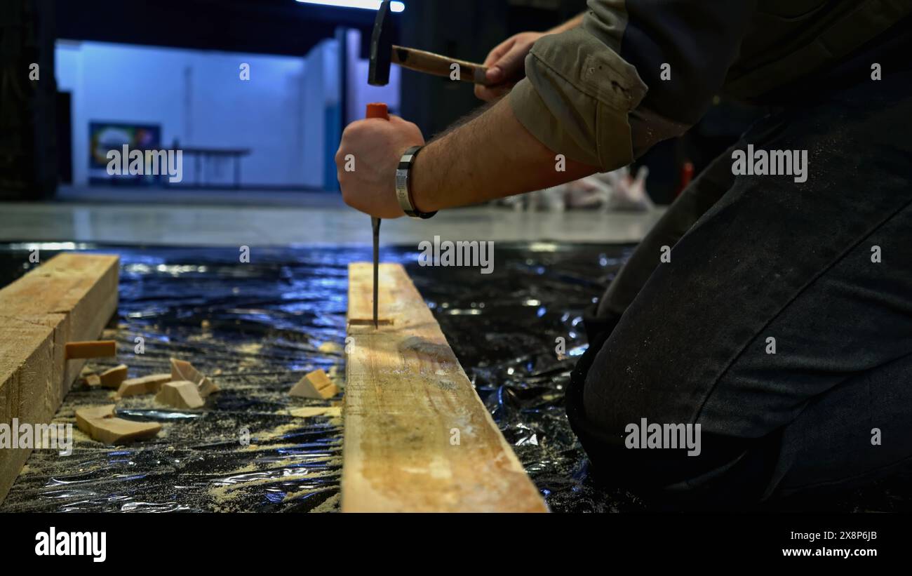 Close up of worker using tools for making holes in wooden beam. Media. Carpentry works for making decorations. Stock Photo