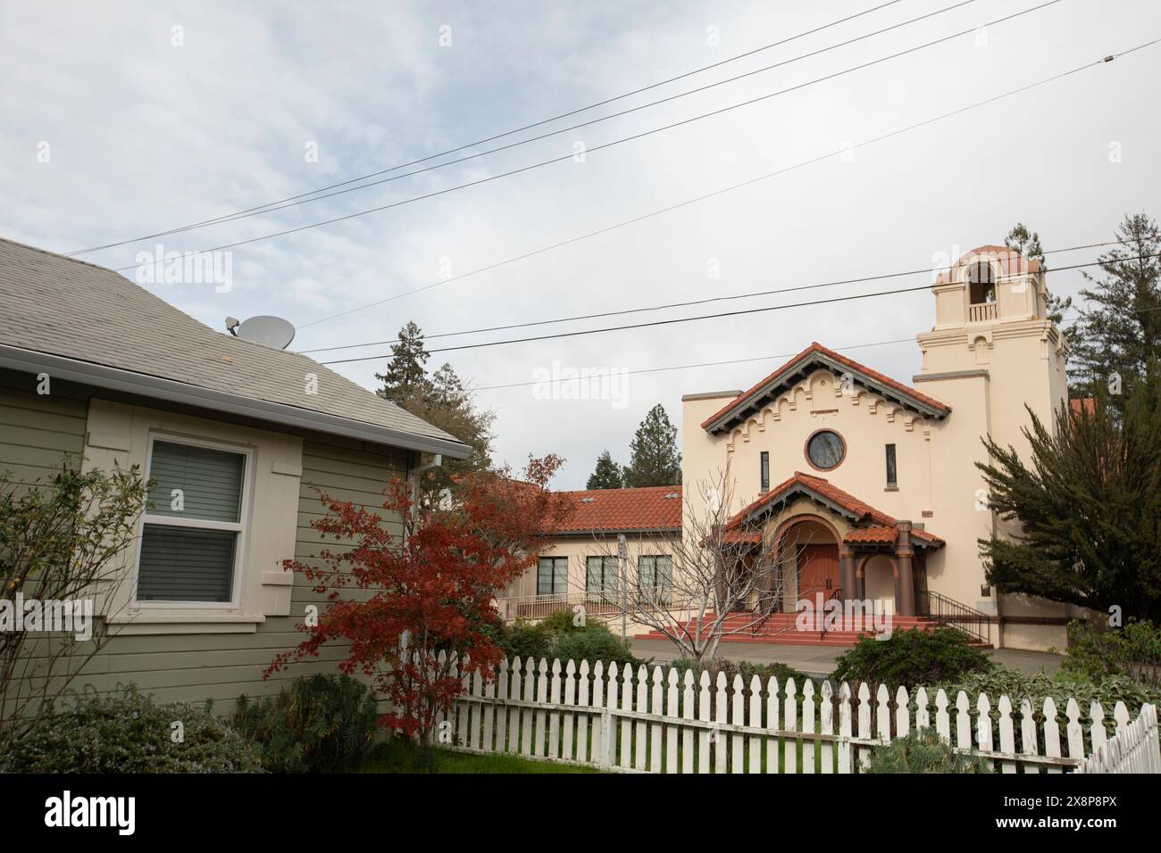 Aumtum cloudy light and foliage frame homes and a church building in