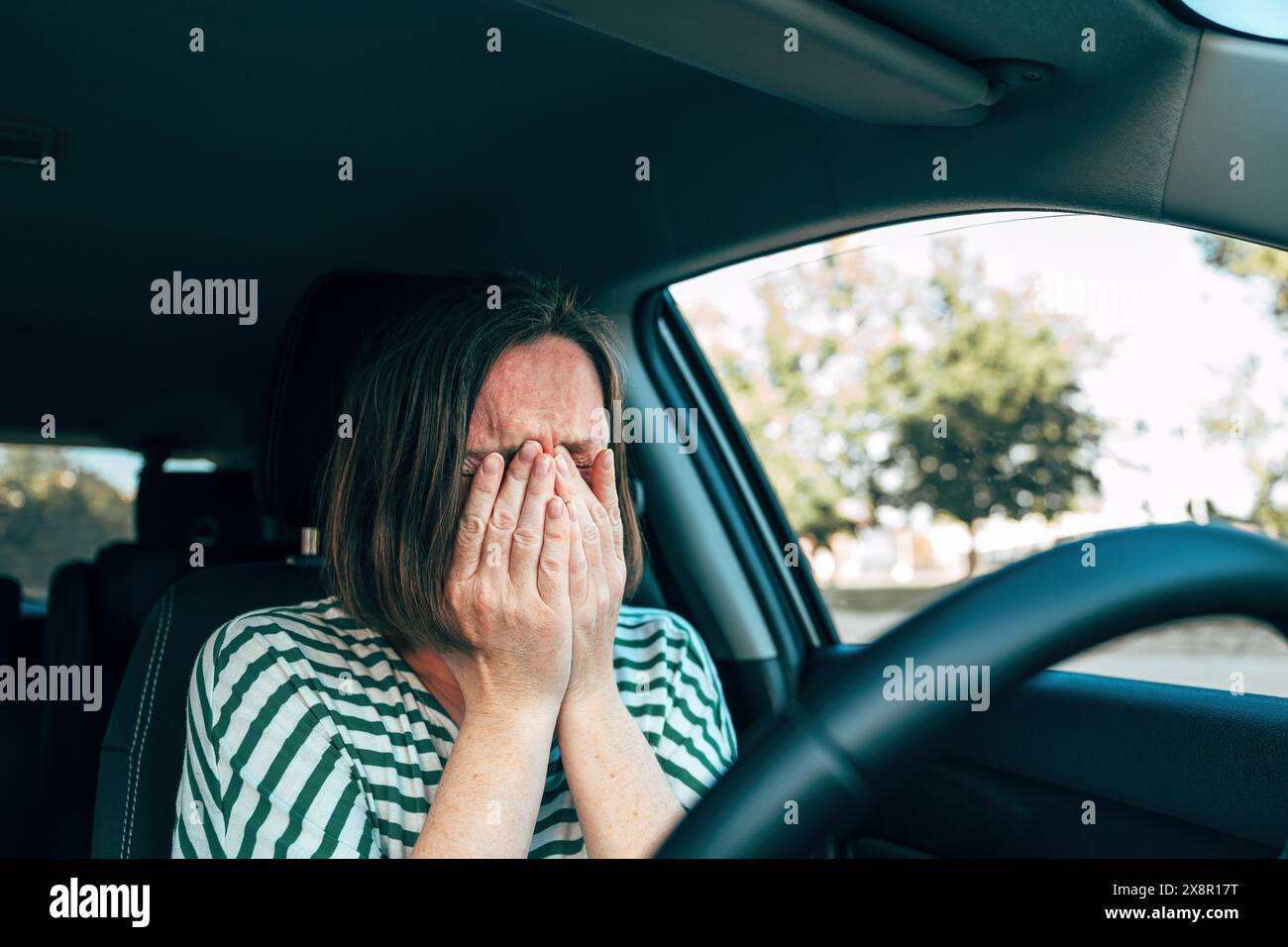 Sad disappointed female driver crying in car, selective focus Stock Photo