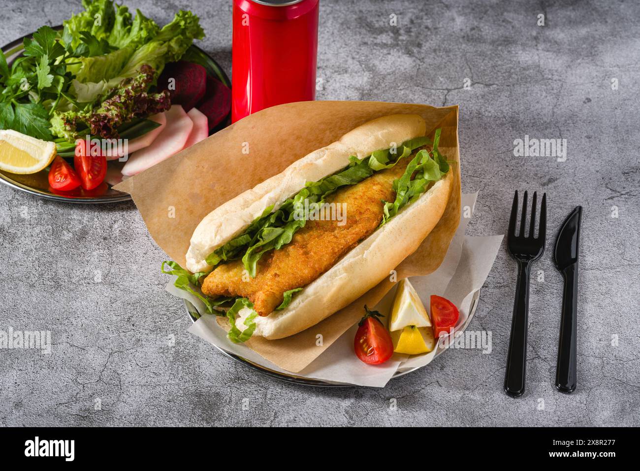 Fried fish sandwich with greens on the stone table. Turkish name Balik Ekmek Stock Photo