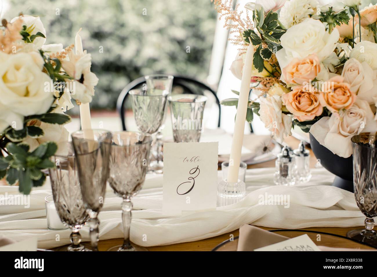 Elegant table setting with florals, crystal glasses, and table number Stock Photo