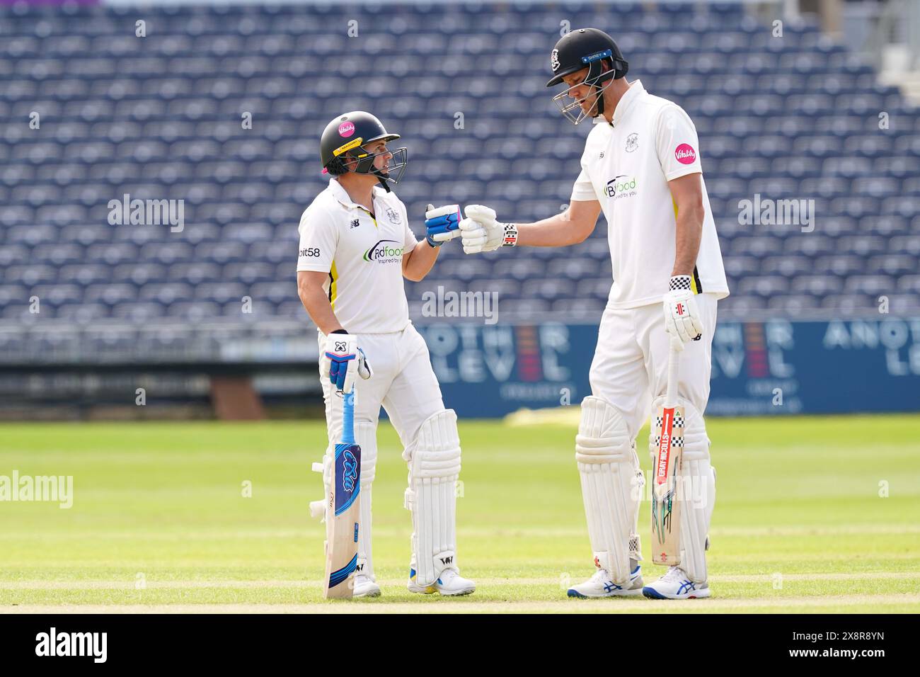 Bristol, UK, 27 May 2024. Gloucestershire's Graeme van Buuren and Beau Webster fist bump during the Vitality County Championship match between Gloucestershire and Derbyshire. Credit: Robbie Stephenson/Gloucestershire Cricket/Alamy Live News Stock Photo