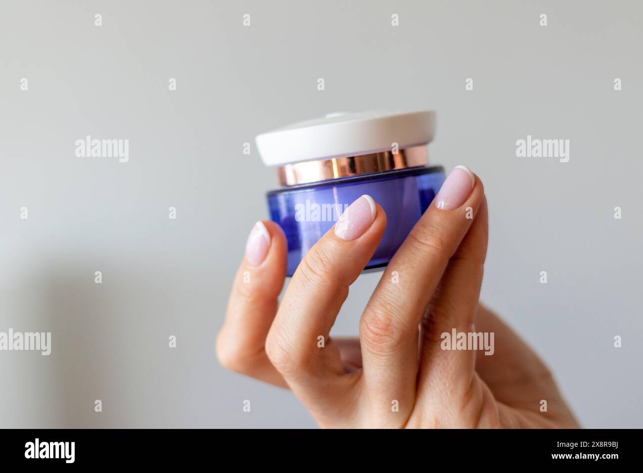 Shot of the beautiful woman's hand holding bottle of skin care product. Stock Photo