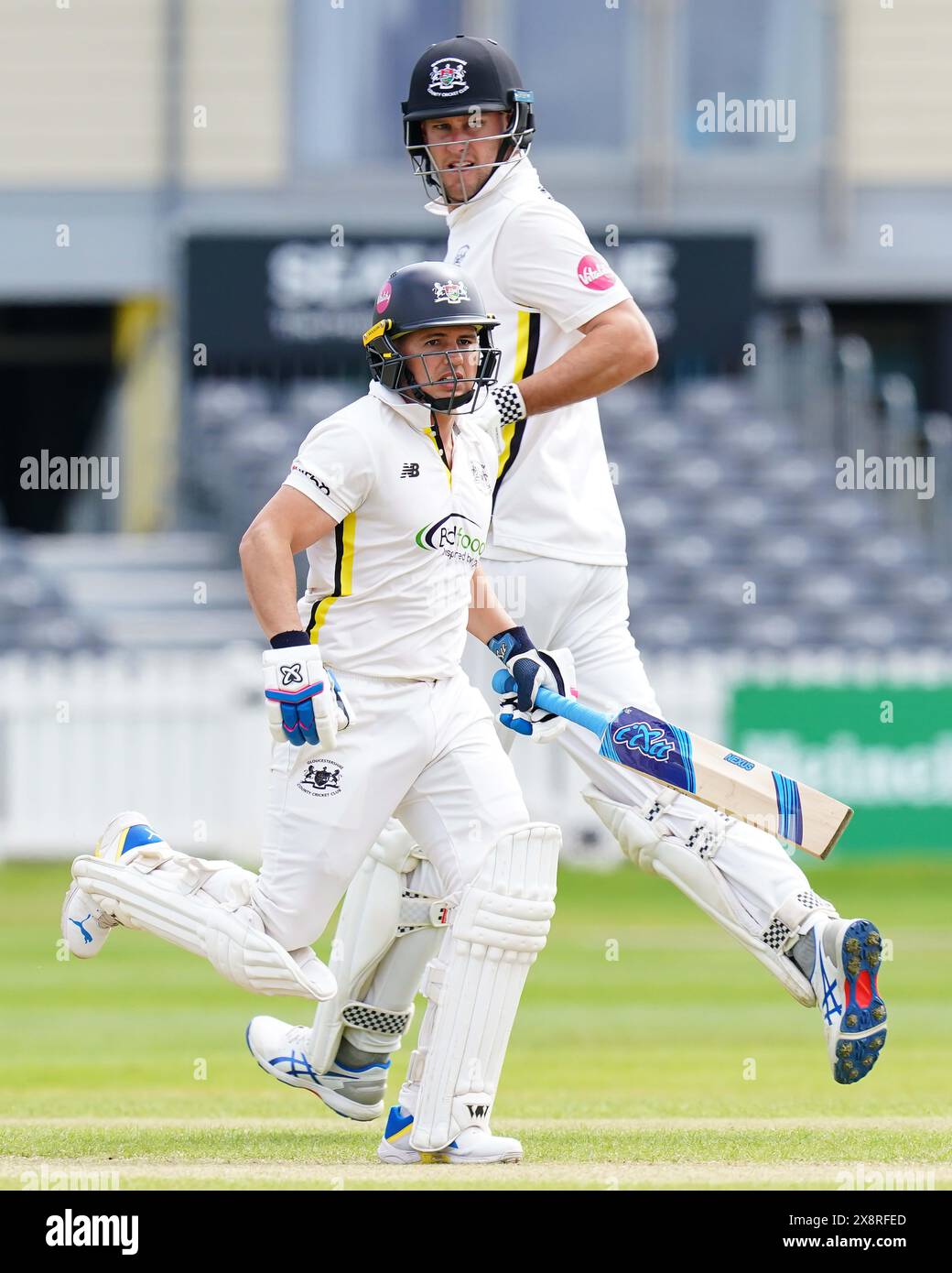 Bristol, UK, 27 May 2024. Gloucestershire's Graeme van Buuren and Gloucestershire's Beau Webster run between the wickets during the Vitality County Championship match between Gloucestershire and Derbyshire. Credit: Robbie Stephenson/Gloucestershire Cricket/Alamy Live News Stock Photo