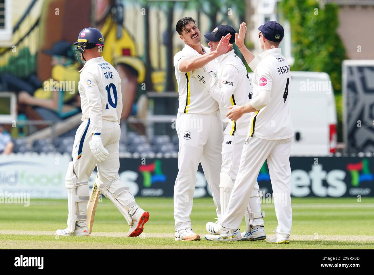 Bristol, UK, 27 May 2024. Gloucestershire's Marchant de Lange celebrates with teammates after taking the wicket of Derbyshire's Luis Reece during the Vitality County Championship match between Gloucestershire and Derbyshire. Credit: Robbie Stephenson/Gloucestershire Cricket/Alamy Live News Stock Photo