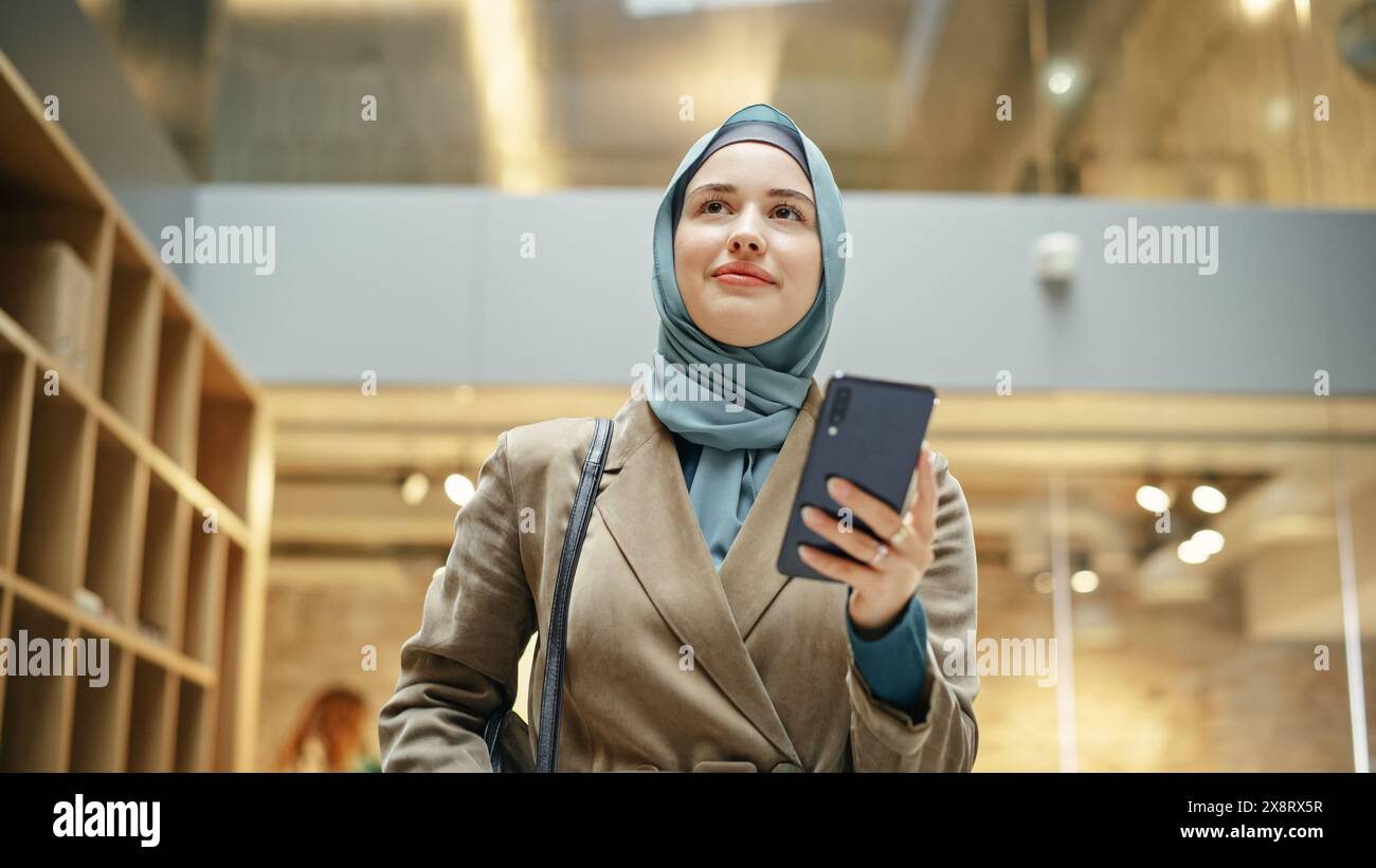 Portrait of Muslim Hijabi Woman Scrolling on her Smartphone While ...