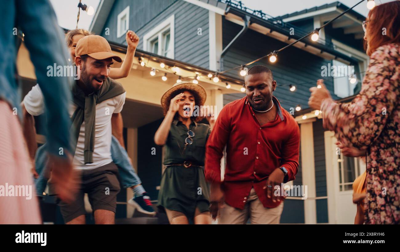 Diverse Multicultural Friends and Family Dancing Together at an Outdoors Garden Party Celebration. Young and Senior People Having Fun on a Perfect Summer Afternoon. Stock Photo
