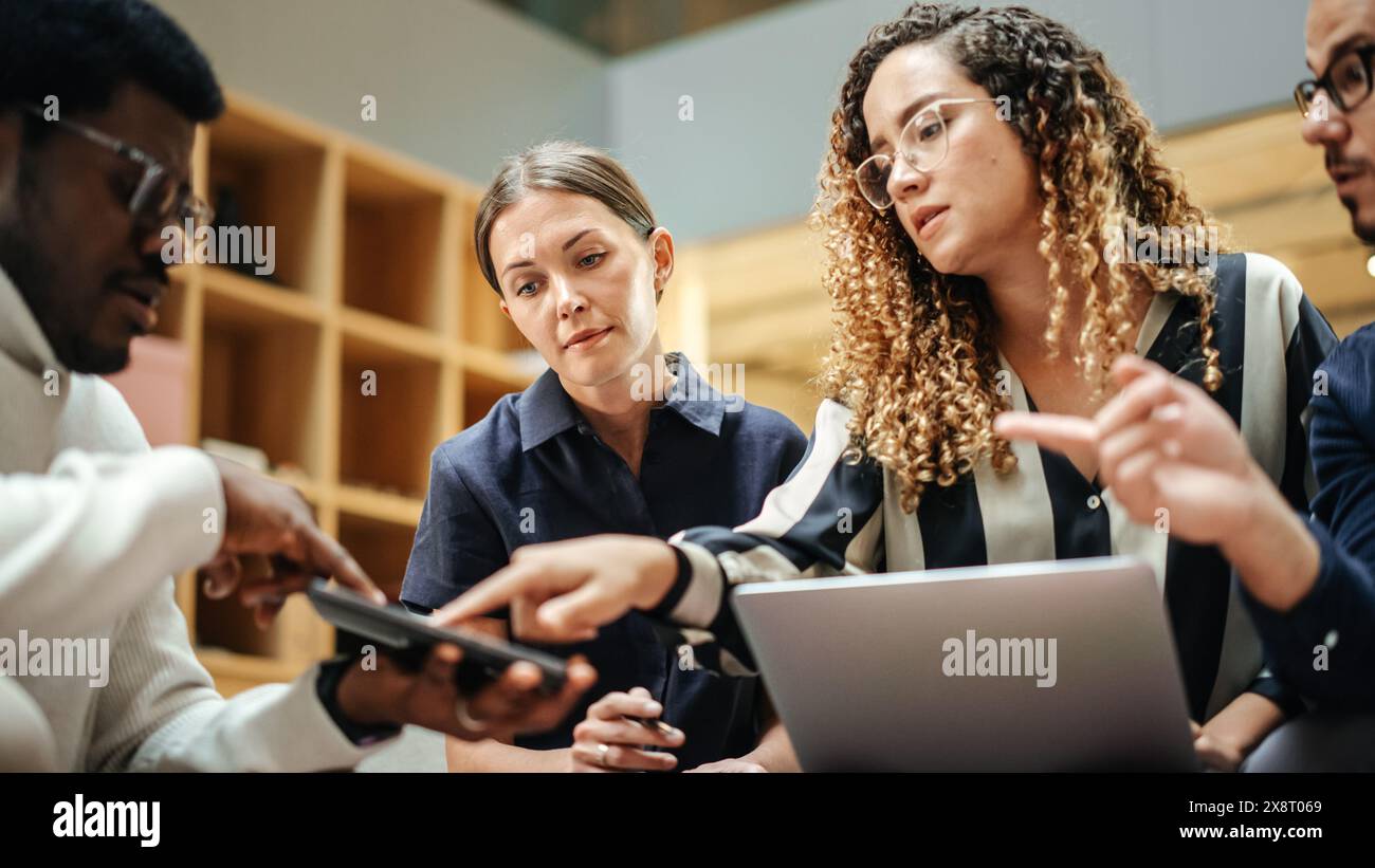 Diverse Group of People Talking in a Casual Modern Meeting Room in Office. Group of Colleagues From Different Ethnicities Working Together as a Team on Crisis Management. Wide Shot Stock Photo