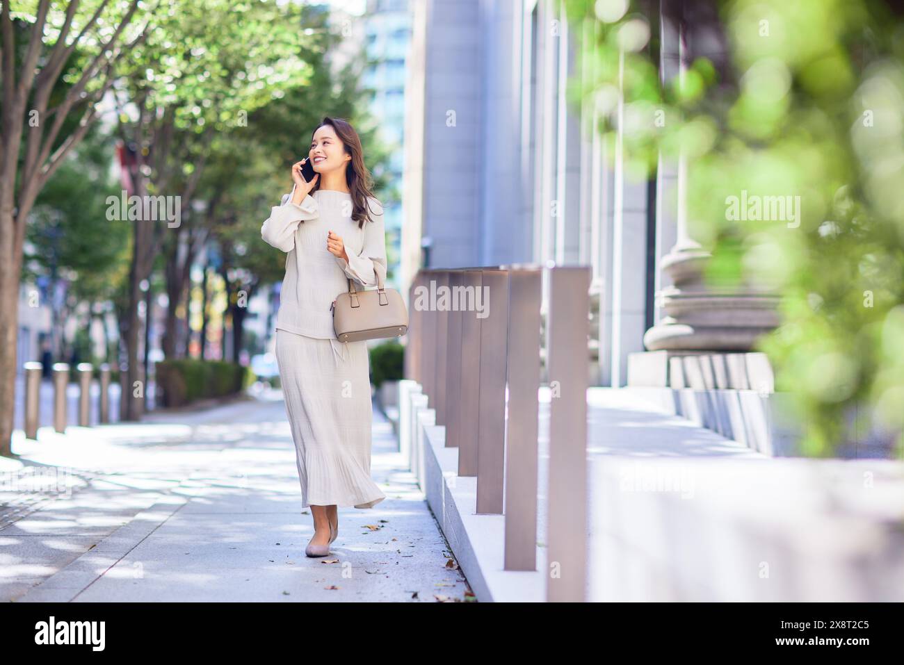 Japanese woman in a white dress walking down a sidewalk Stock Photo - Alamy