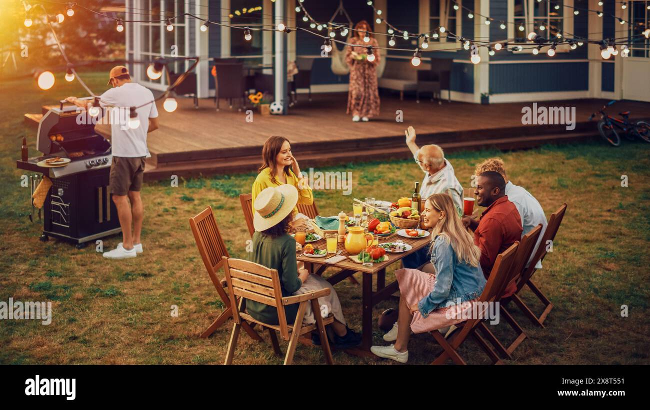 Big Family and Friends Celebrating Outside at Home. Diverse Group of Children, Adults and Old People Gathered at a Table, Having Fun Conversations. Preparing Barbecue and Eating Vegetables. Stock Photo