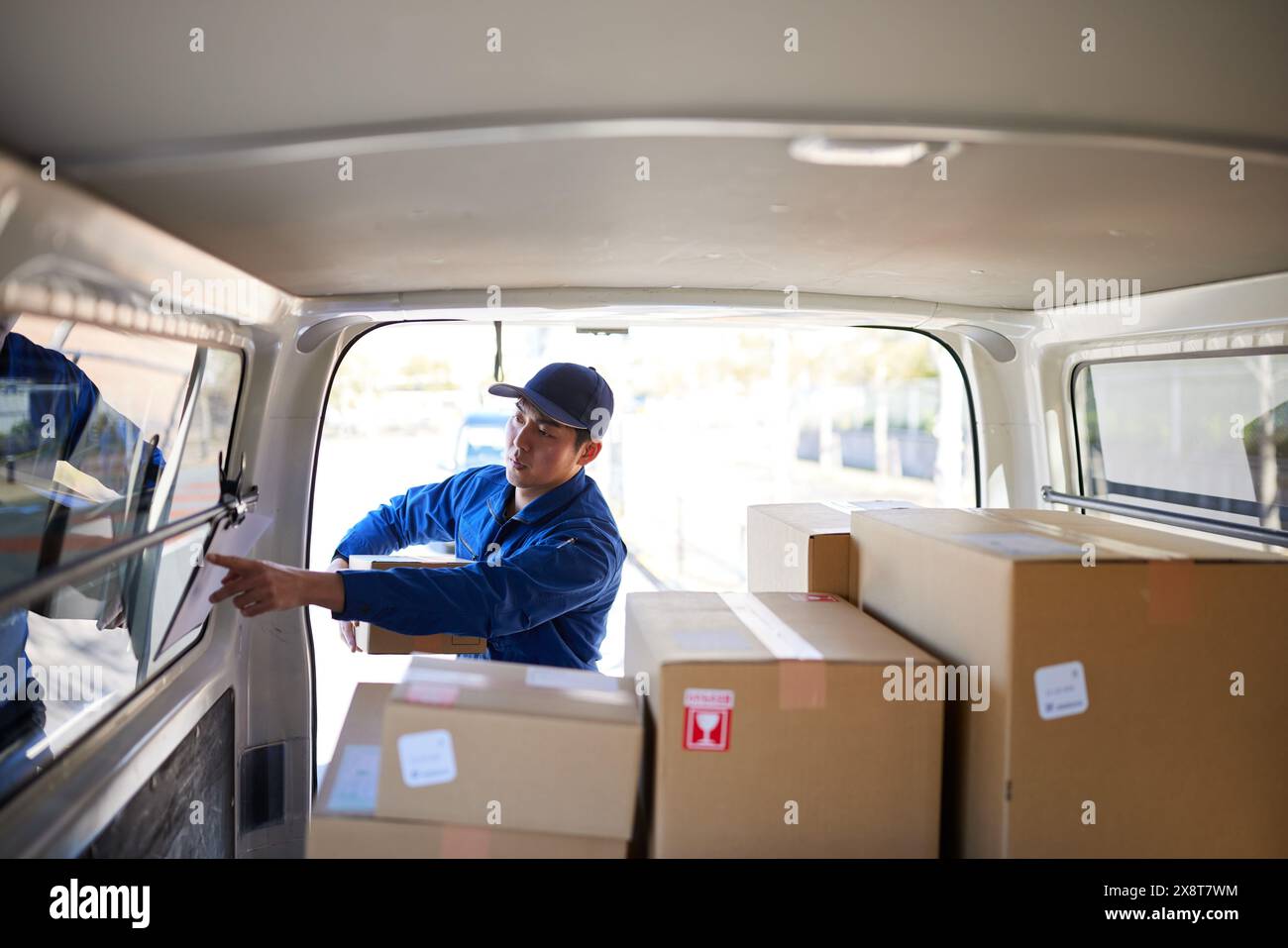 Japanese delivery man checking boxes in the car Stock Photo - Alamy