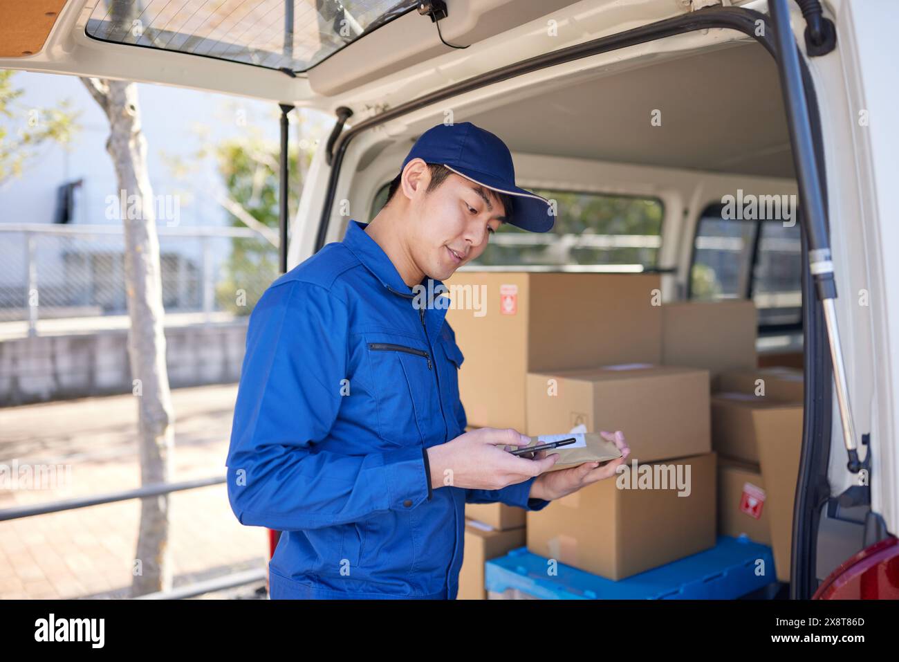 Japanese delivery man checking boxes in the car Stock Photo - Alamy