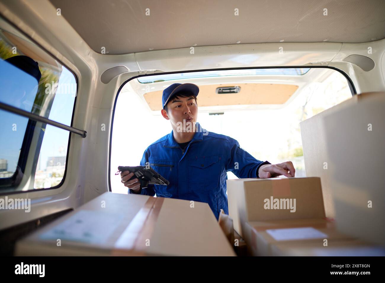 Japanese delivery man checking boxes in the car Stock Photo - Alamy