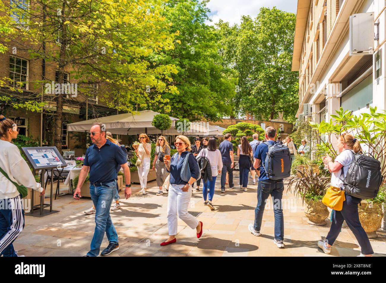 LONDON, UK - MAY 25, 2024: People enjoy sunny spring day in Chelsea, an affluent area known for the smart boutiques and high-end restaurants Stock Photo