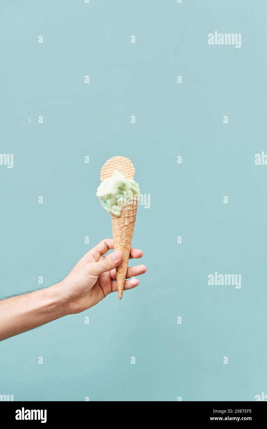 Ice cream cone on a blue background. man holding the ice cream by hand ...