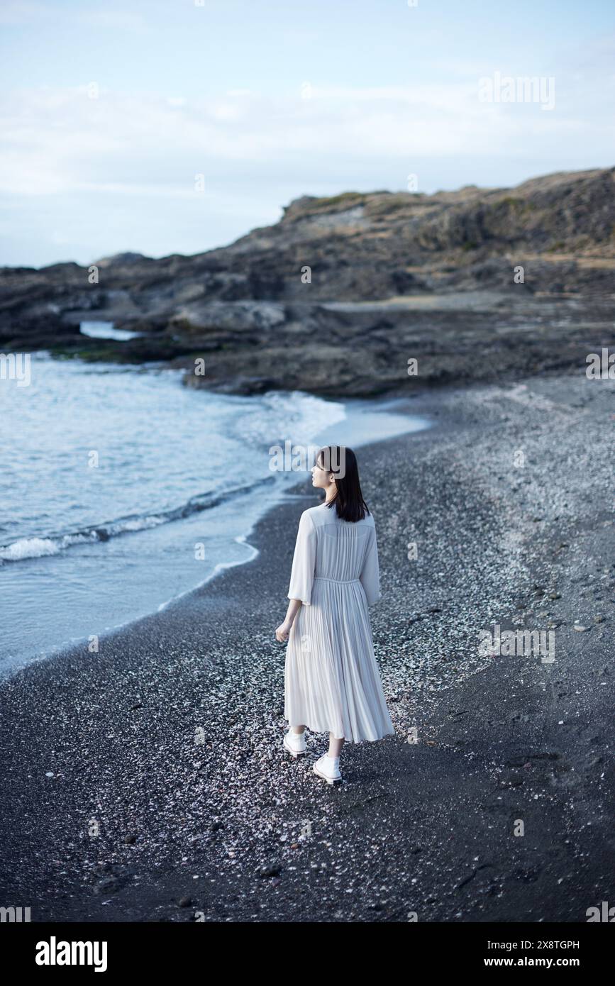Japanese woman in a white dress standing on the beach Stock Photo - Alamy