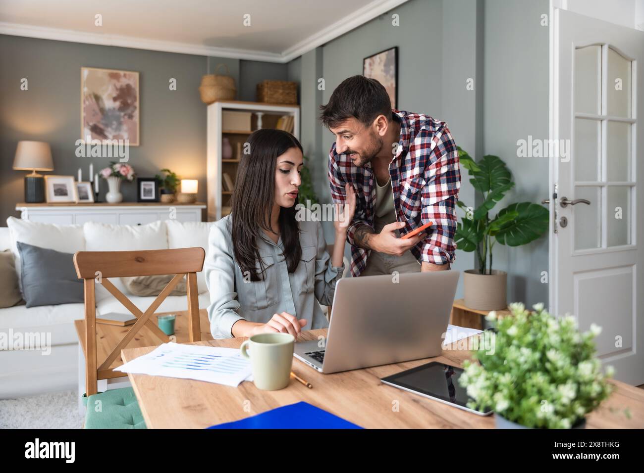 Young couple, freelancers small internet business owners, professional designers, computer software developers, working together at home, on new proje Stock Photo