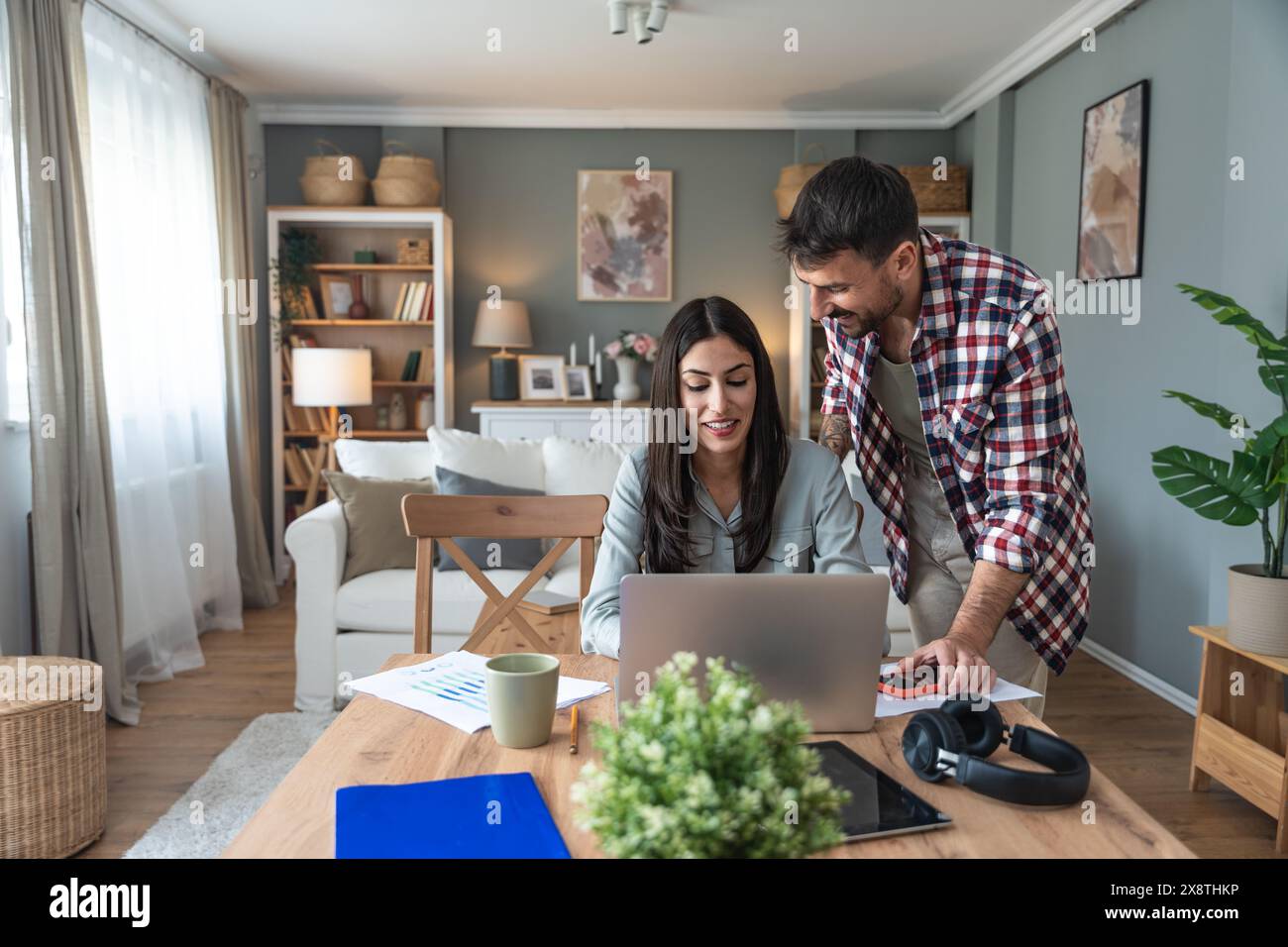Young couple, freelancers small internet business owners, professional designers, computer software developers, working together at home, on new proje Stock Photo