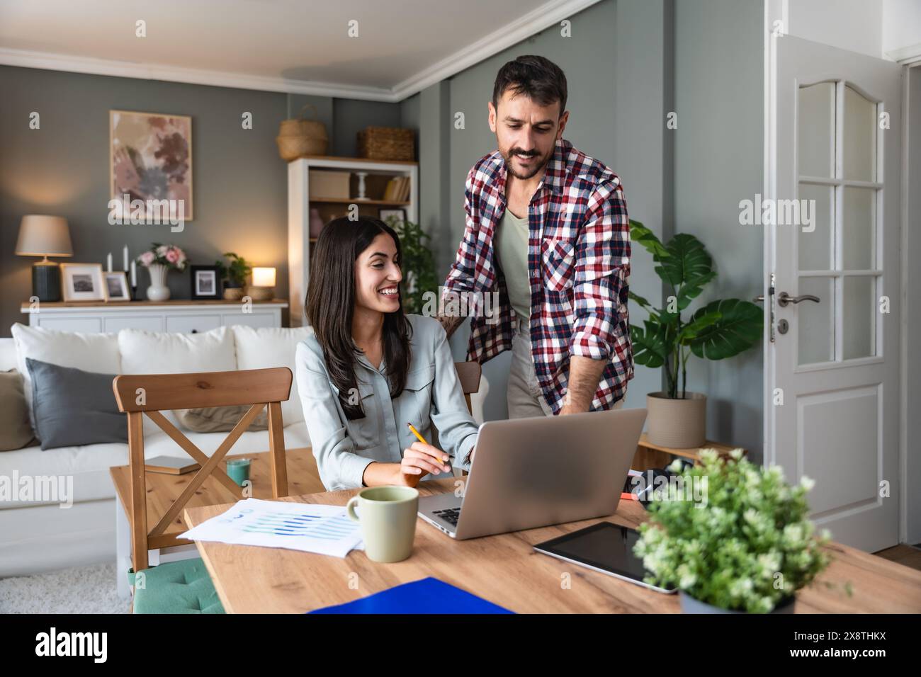 Young couple, freelancers small internet business owners, professional designers, computer software developers, working together at home, on new proje Stock Photo