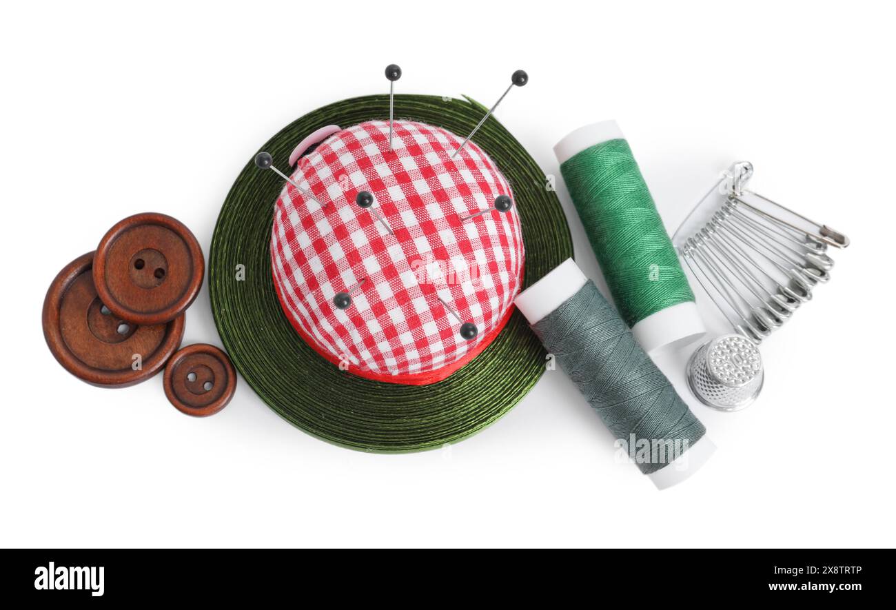 Pincushion, pins and other sewing tools isolated on white, top view — free download