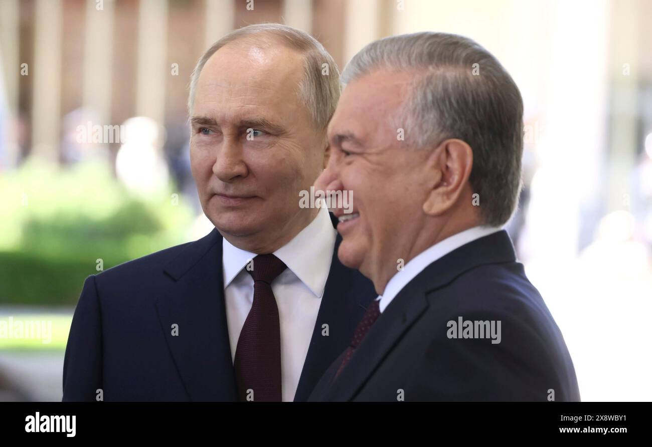 Tashkent, Uzbekistan. 27th May, 2024. Uzbek President Shavkat Mirziyoyev, right, stands with Russian President Vladimir Putin during the formal arrival ceremony at the Kuksaroy Presidential Palace, May 27, 2024, in Tashkent, Uzbekistan. Credit: Mikhail Metzel/Kremlin Pool/Alamy Live News Stock Photo